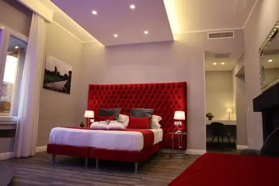a bedroom with a red bed with a red headboard at MILLINA SUITES IN NAVONA in Rome