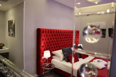 a bedroom with a red padded headboard and a bed at MILLINA SUITES IN NAVONA in Rome
