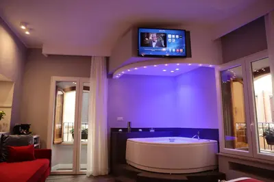 a bathroom with a tub and a tv on the wall at MILLINA SUITES IN NAVONA in Rome