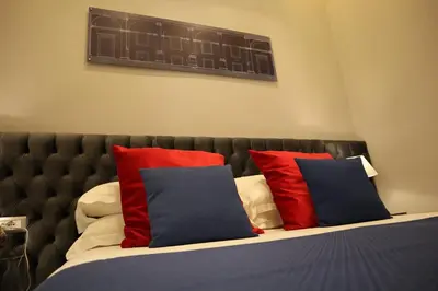 a bedroom with a bed with red and blue pillows at MILLINA SUITES IN NAVONA in Rome