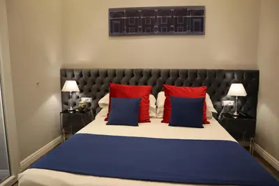 a bedroom with a large bed with red and blue pillows at MILLINA SUITES IN NAVONA in Rome