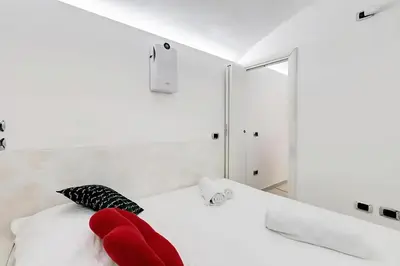 a bedroom with a white bed with red pillows at Cherì Navona in Rome