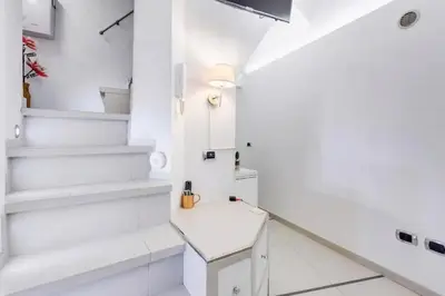 a white bathroom with white stairs and a white stool at Cherì Navona in Rome