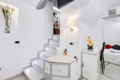 a white staircase in a white room with a bed at Cherì Navona in Rome