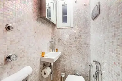 a bathroom with a sink and a white tiled wall at Cherì Navona in Rome