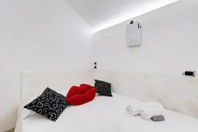 a white bed with two pillows and a red heart at Cherì Navona in Rome