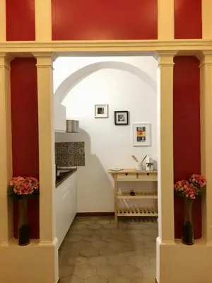 a kitchen with red and white walls and vases with flowers at Appart. delizioso nel centro di Roma Vaticano in Rome