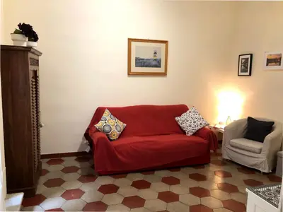 a living room with a red couch and a chair at Appart. delizioso nel centro di Roma Vaticano in Rome