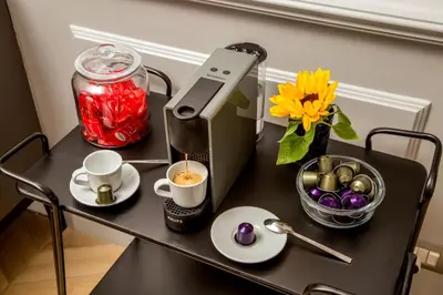 a table with a coffee maker and a vase of flowers at Borgo Pio Charme in Rome