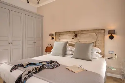 a bedroom with a large white bed with a book on it at Borgo Pio Charme in Rome