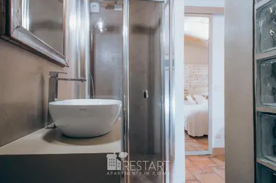 a bathroom with a bowl sink on a counter at Restart Accommodations Rosa in Rome