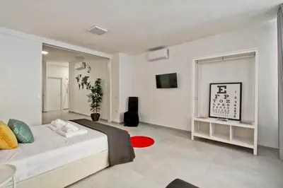 a white bedroom with a bed and a tv at Vatican Loft - Rooms & Apartments in Rome