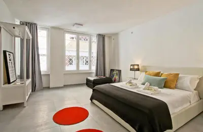 a bedroom with a large bed and a red rug at Vatican Loft - Rooms & Apartments in Rome