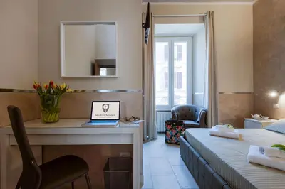 a bedroom with a desk and a laptop on a table at Suite Horti Sallustiani in Rome