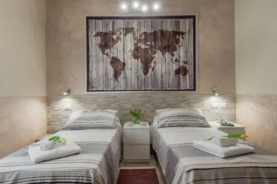 two beds in a room with a world map on the wall at Suite Horti Sallustiani in Rome
