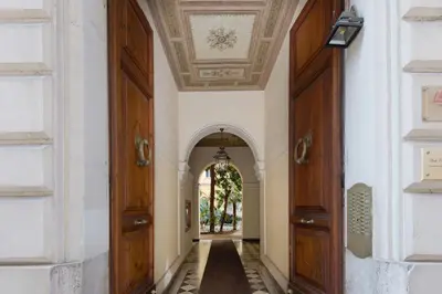 an open hallway with an archway and wooden doors at Suite Horti Sallustiani in Rome