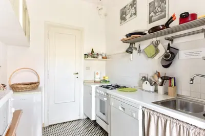 a white kitchen with a sink and a stove at La Canterina al Vaticano in Rome