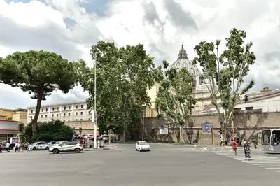 a city street with cars and a building and trees at La Canterina al Vaticano in Rome
