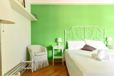 a green bedroom with a bed and a chair at La Canterina al Vaticano in Rome