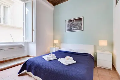 a bedroom with a blue bed with towels on it at Domus Florea in Rome