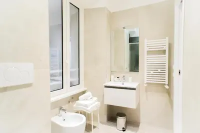 a white bathroom with a sink and a mirror at The Dream Of Colosseum in Rome