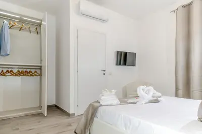 a white bedroom with a bed and a closet at The Dream Of Colosseum in Rome