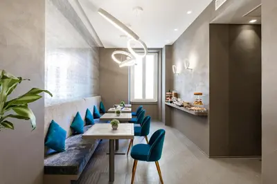 a dining room with a table and blue chairs at A World Aparts - Barberini Boutique Hotel in Rome