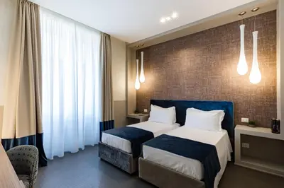 a bedroom with two beds and a brick wall at A World Aparts - Barberini Boutique Hotel in Rome