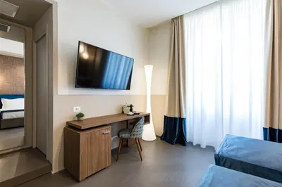 a hotel room with a desk and a tv on the wall at A World Aparts - Barberini Boutique Hotel in Rome