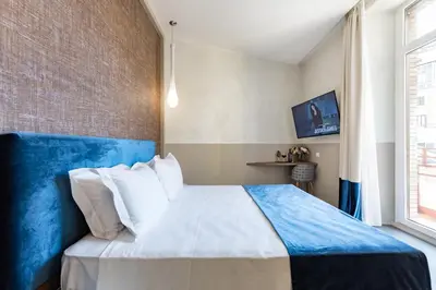 a bedroom with a blue and white bed and a window at A World Aparts - Barberini Boutique Hotel in Rome