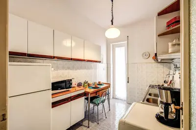 a kitchen with a white refrigerator and a table at BlueClassicHome in Rome