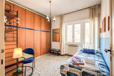 a bedroom with a bed and a desk and a window at BlueClassicHome in Rome