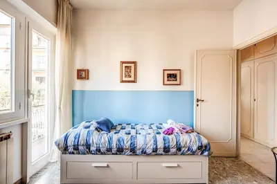a bedroom with a bed with a blue headboard at BlueClassicHome in Rome