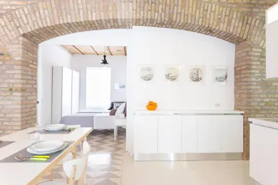 a kitchen with white cabinets and a brick wall at Lilli Vatican White Domus in Rome