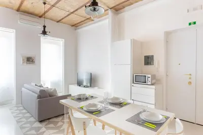 a white living room with a table and a couch at Lilli Vatican White Domus in Rome