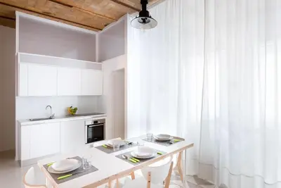a white kitchen with a table and chairs at Lilli Vatican White Domus in Rome