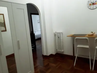 a room with a table and a desk and a mirror at A casa di Robi in Rome