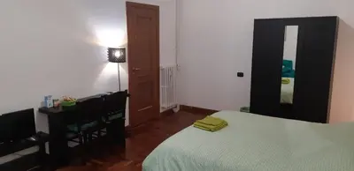a bedroom with a bed and a desk and a mirror at A casa di Robi in Rome
