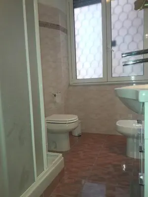 a bathroom with a toilet and a sink and a window at A casa di Robi in Rome
