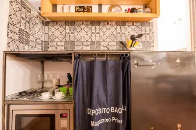 a small kitchen with a refrigerator and a curtain in it at Restart Accommodations Balestra in Rome