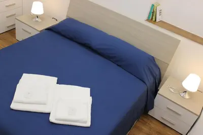 a bedroom with a blue bed with two white towels on it at Locazione Turistica 