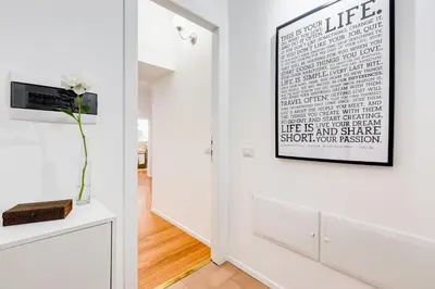 a living room with white walls and a picture on the wall at Lovely and modern nest near the Colosseum in Rome