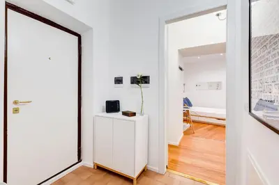 a white hallway with a door leading to a bedroom at Lovely and modern nest near the Colosseum in Rome