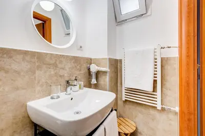 a bathroom with a white sink and a mirror at Lovely and modern nest near the Colosseum in Rome