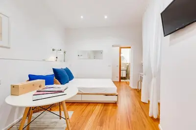 a white room with a bed and a table at Lovely and modern nest near the Colosseum in Rome