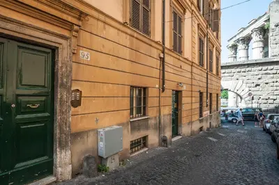 a building with a green door on the side of a street at Rome As You Feel - Baccina 95 Forum Apartment in Rome