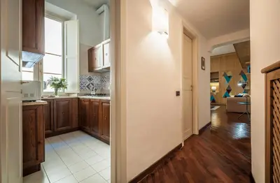 an open kitchen with wooden cabinets and a window at Rome As You Feel - Baccina 95 Forum Apartment in Rome