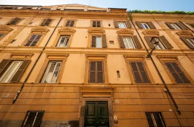a building with many windows and a green door at Rome As You Feel - Baccina 95 Forum Apartment in Rome