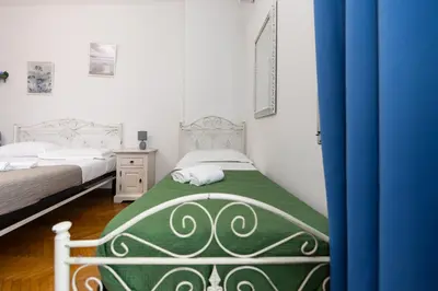 a bedroom with two beds and a blue curtain at L'Imperiale RomaTrastevere in Rome
