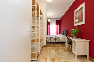 a bedroom with red walls and a desk and a bed at L'Imperiale RomaTrastevere in Rome
